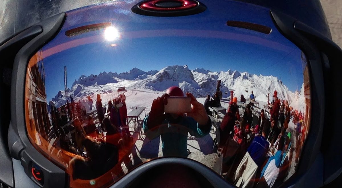 reflection of skiers in a pair of ski goggles